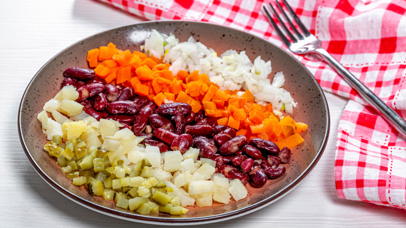 Овощи и фасоль нарезанные на тарелке 