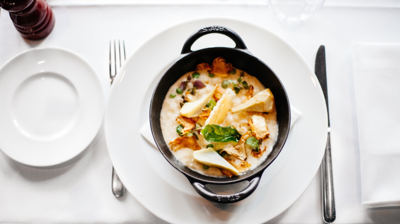 Суп в миске стоит на белой тарелке 