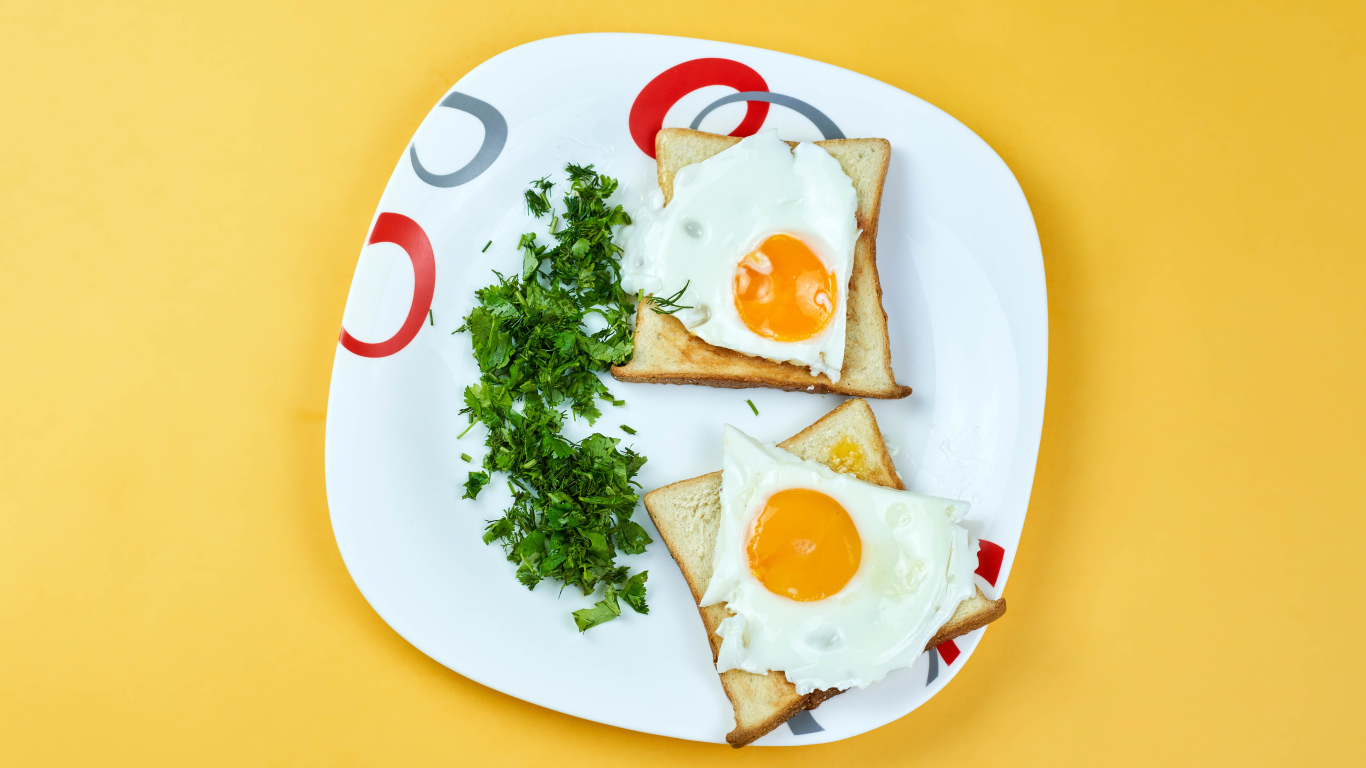 Тосты с яичницей на тарелке с зеленью петрушки 