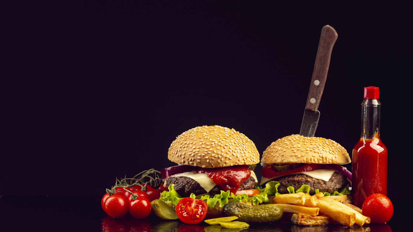 Два гамбургера на столе с ножом, овощами и кетчупом 