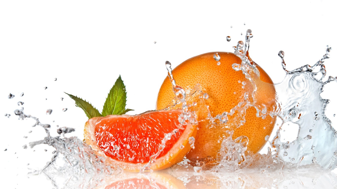 Большой спелый апельсин в брызгах воды на белом фоне