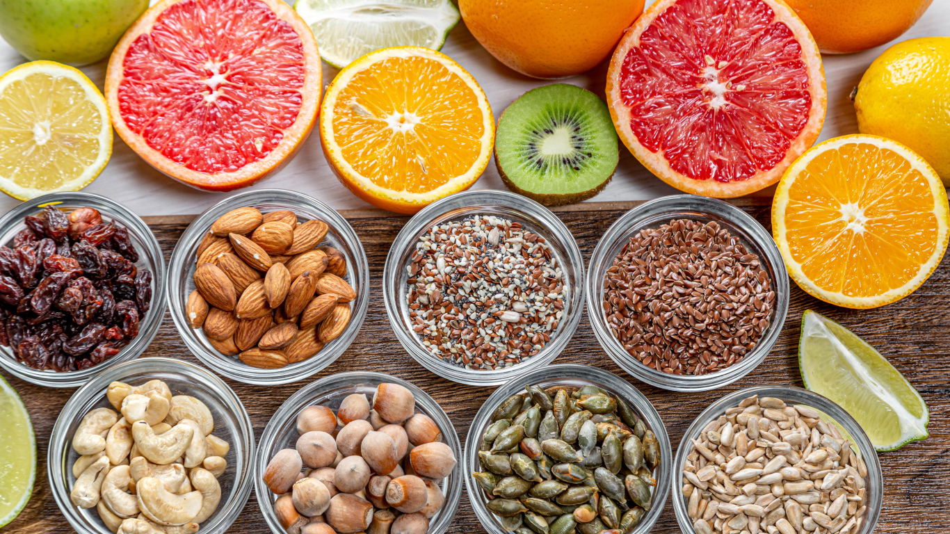 Орехи, зерна и цитрусовые фрукты на столе