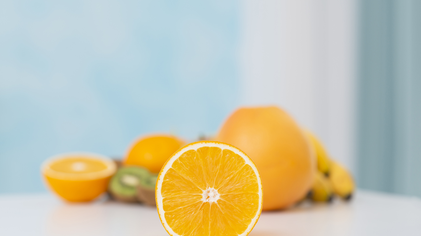 Оранжевые апельсины с киви на столе 