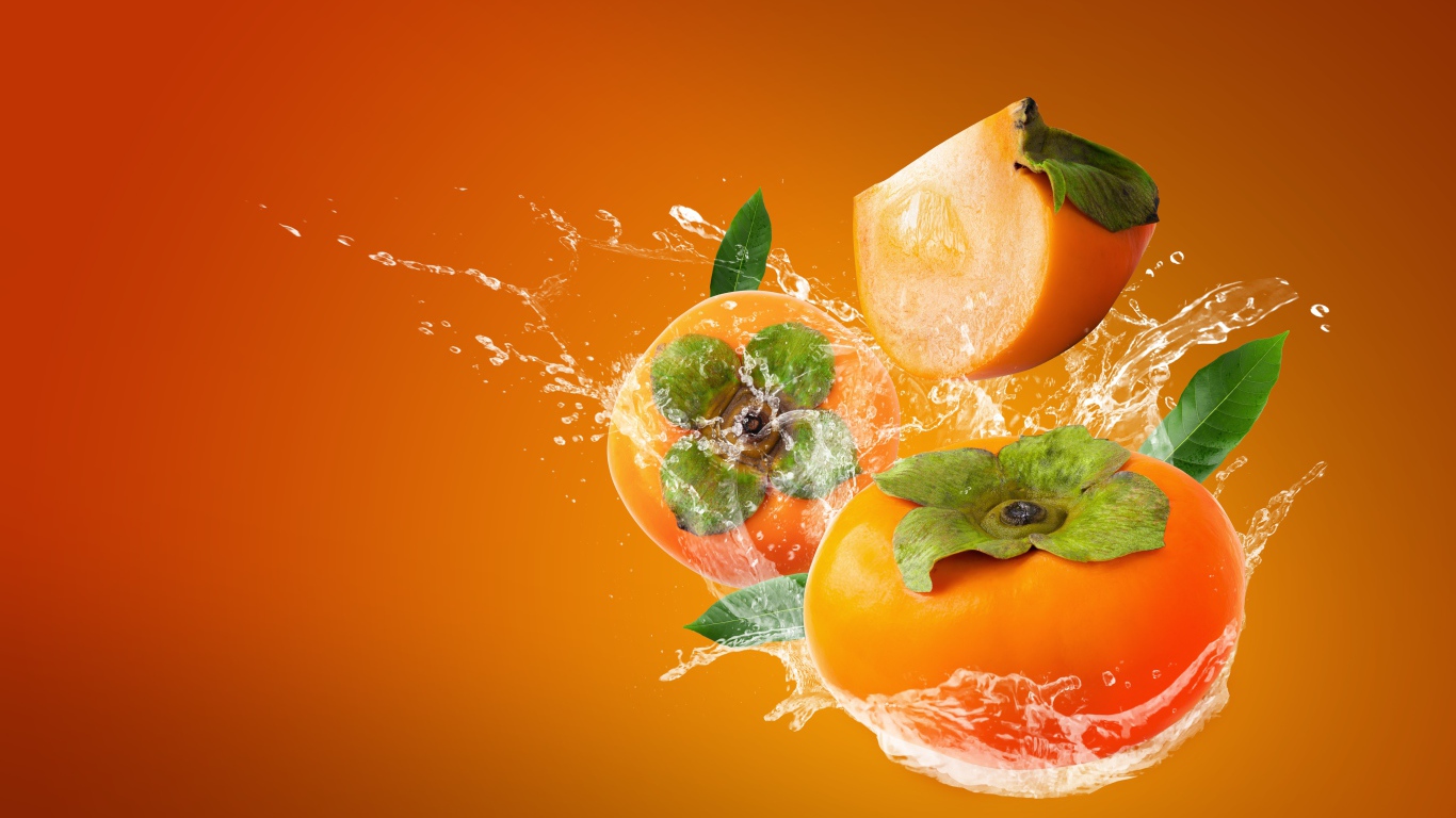 Хурма в брызгах воды на оранжевом фоне