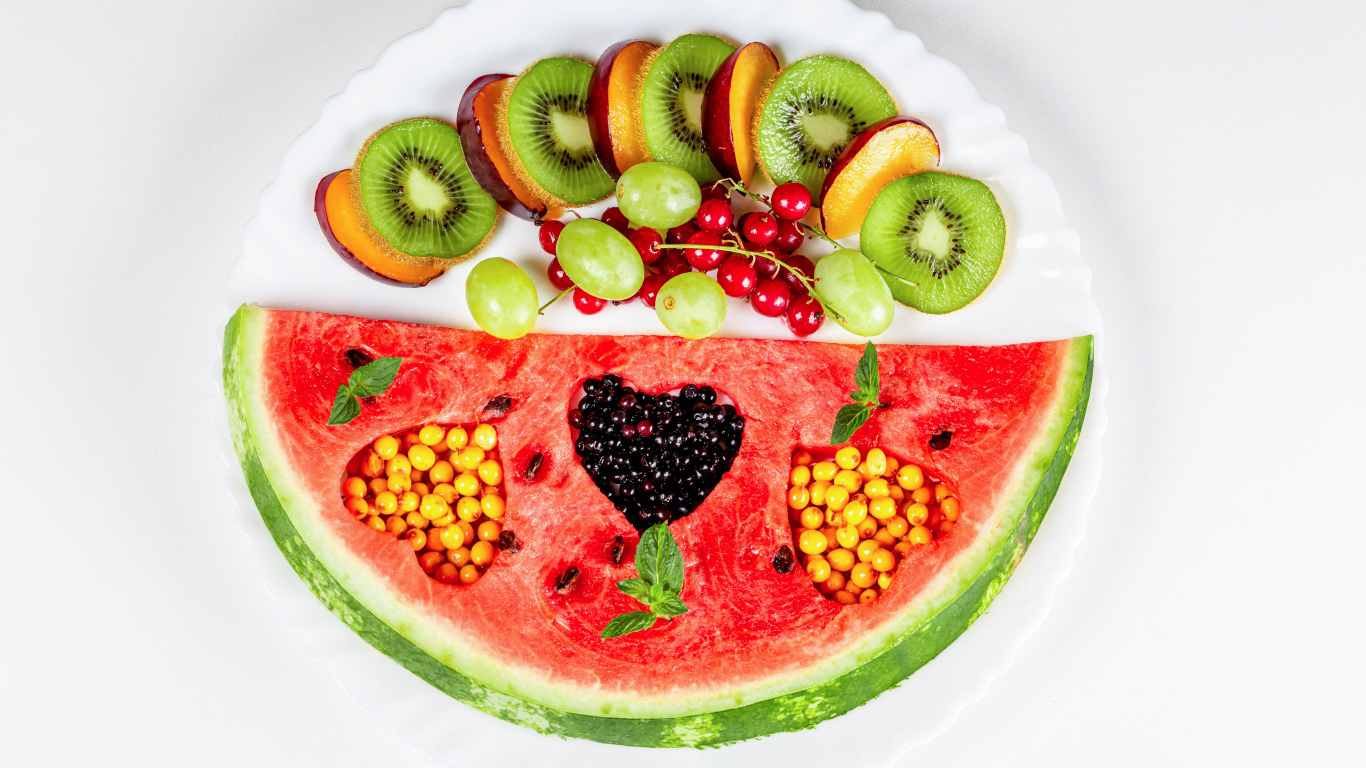 Кусок арбуза на тарелке с киви и ягодами 