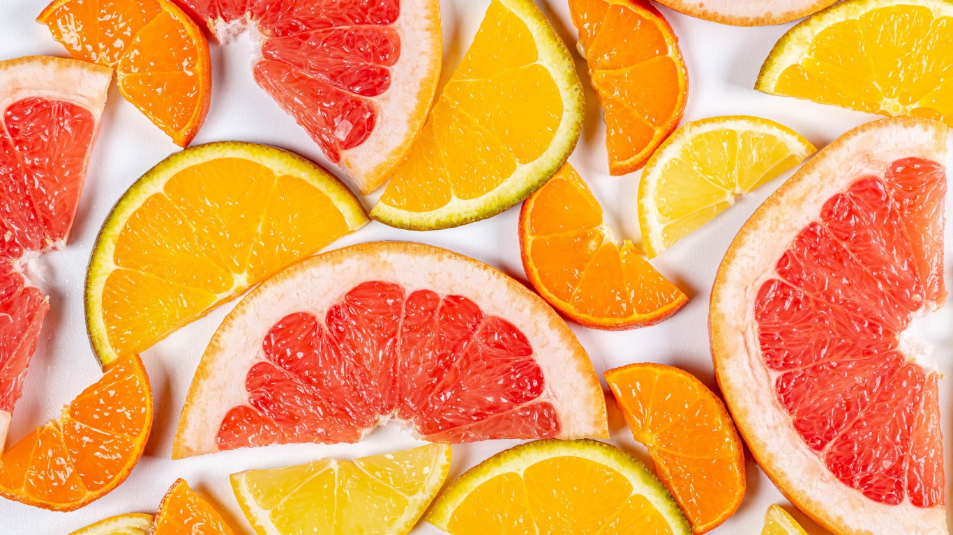 Кусочки апельсина, лимона и грейпфрута на белом фоне