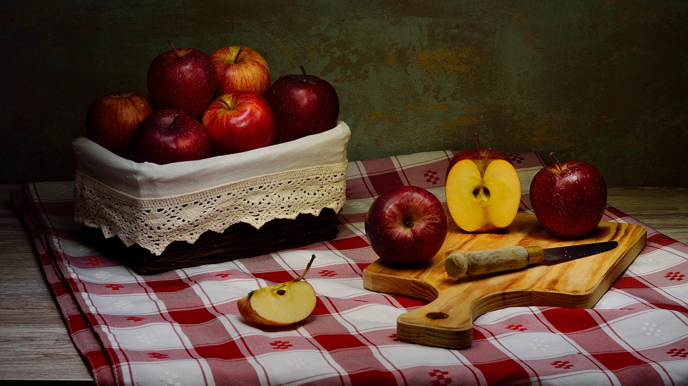 Спелые красные яблоки на столе с ножом