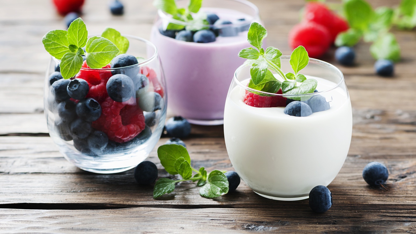 Вкусный йогурт с ягодами черники и малины на столе 