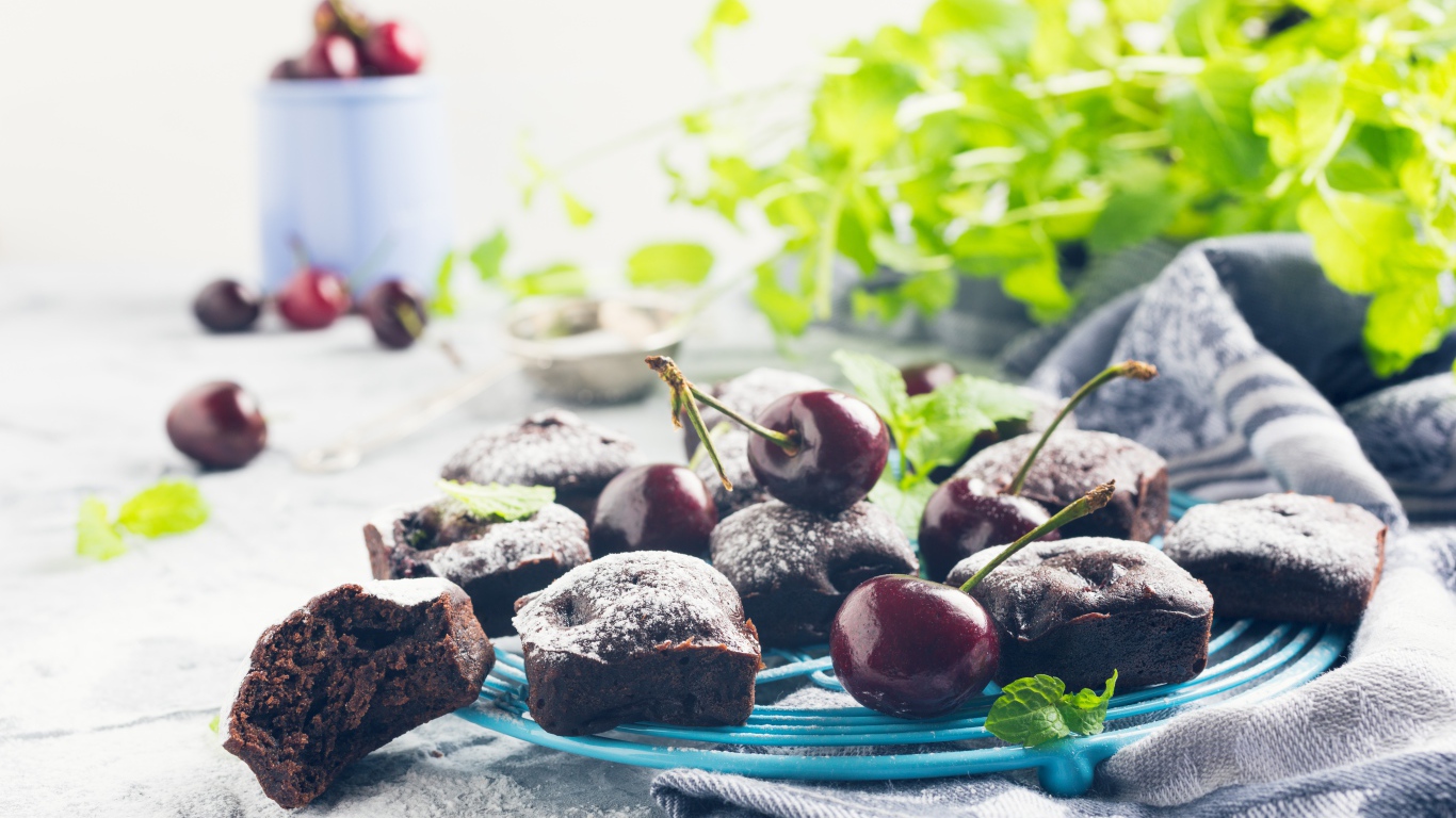 Шоколадные кексы на тарелке с ягодами черешни 