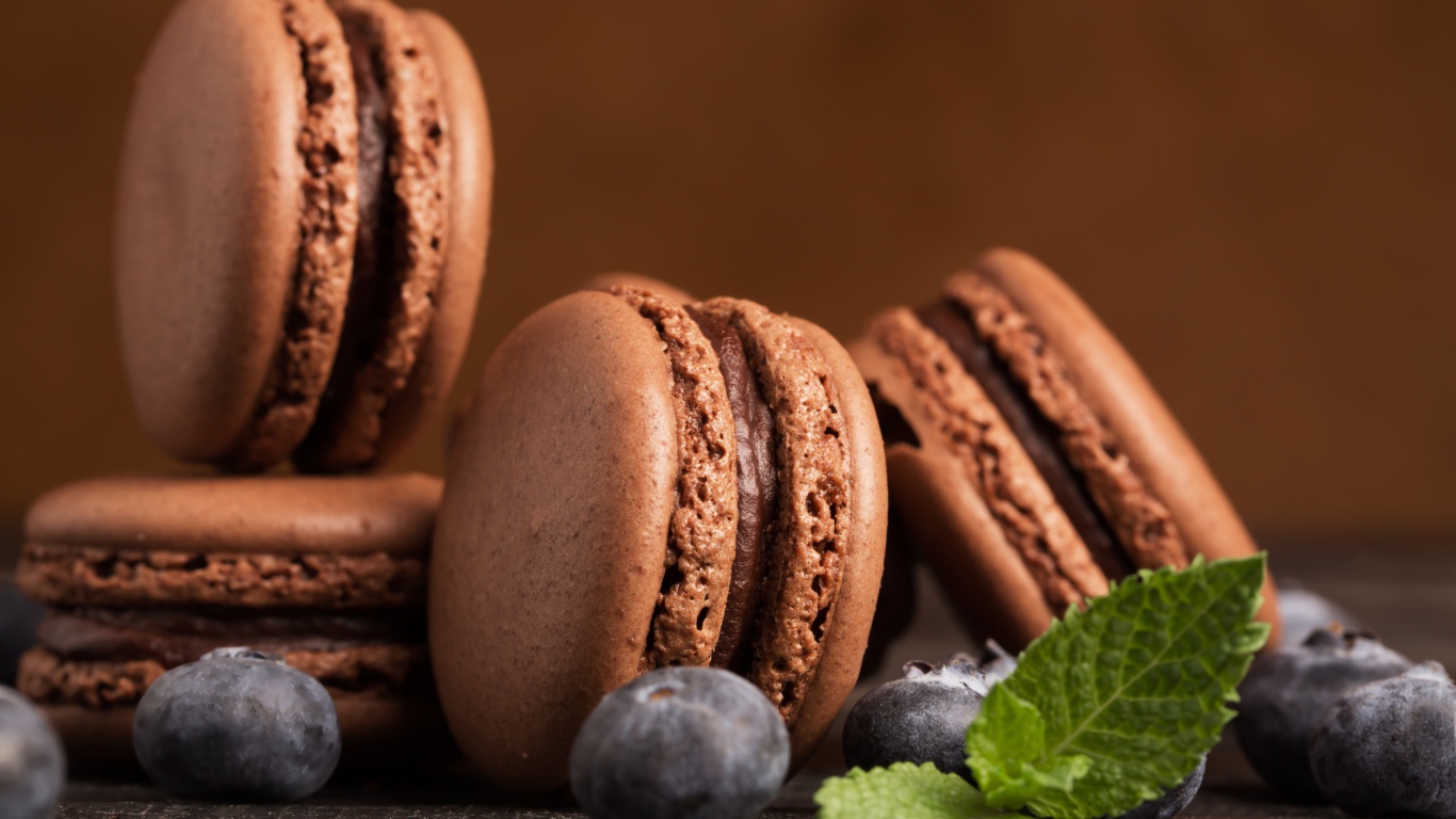 Шоколадный десерт макарон на столе с черникой 