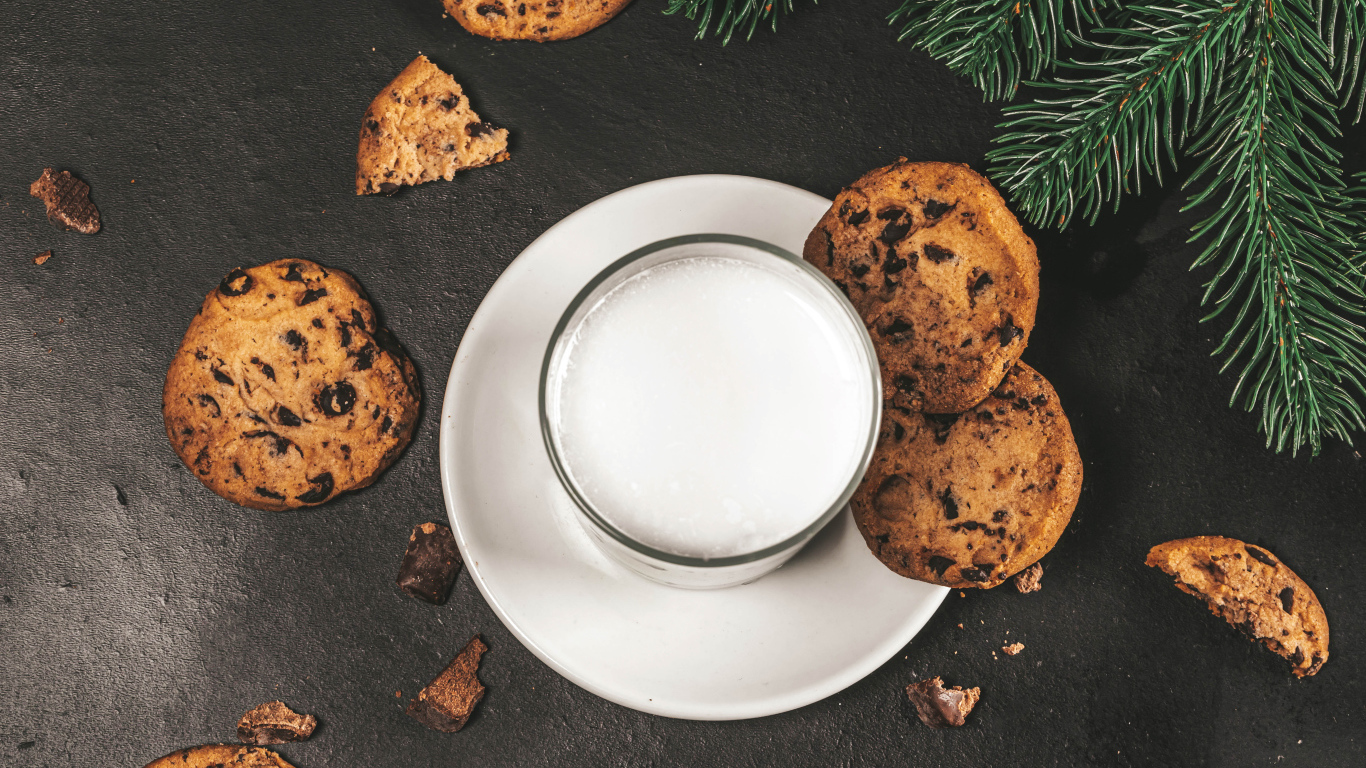 Печенье с шоколадом на столе со стаканом молока 