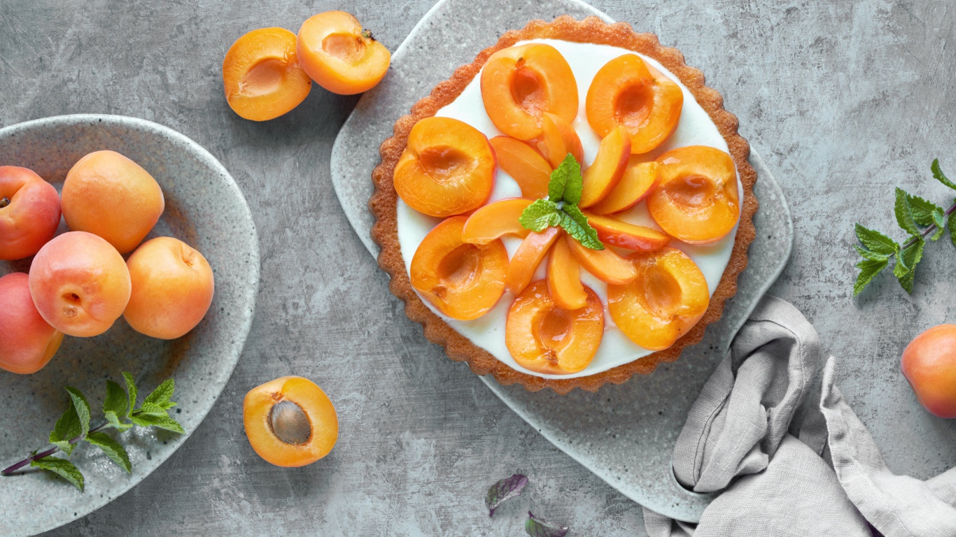 Пирог с кремом и абрикосами на столе 