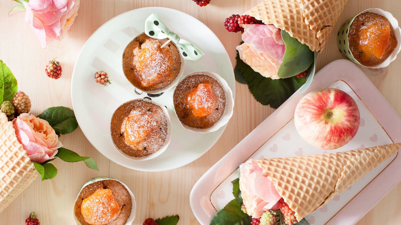 Вкусные кексы с абрикосом на столе с вафельными рожками с розой и ежевикой