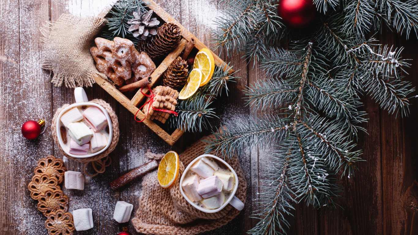 Зеленая еловая ветка на столе с печеньем и шишками