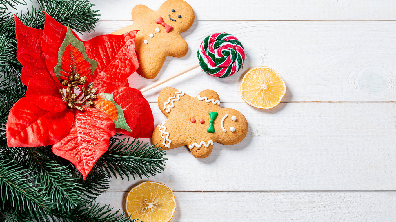 Праздничное печенье с леденцом и еловой веткой на столе 