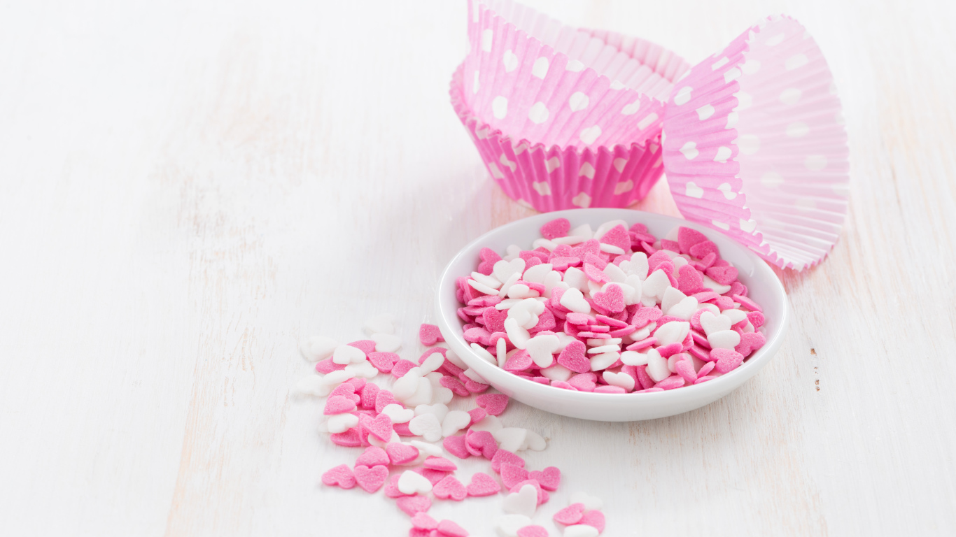 Маленькие белые и розовые сердечки на столе 