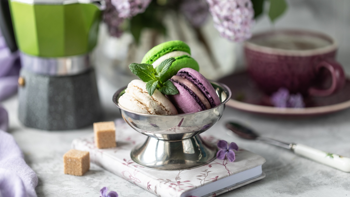 Три печенья макарун на столе с блокнотом