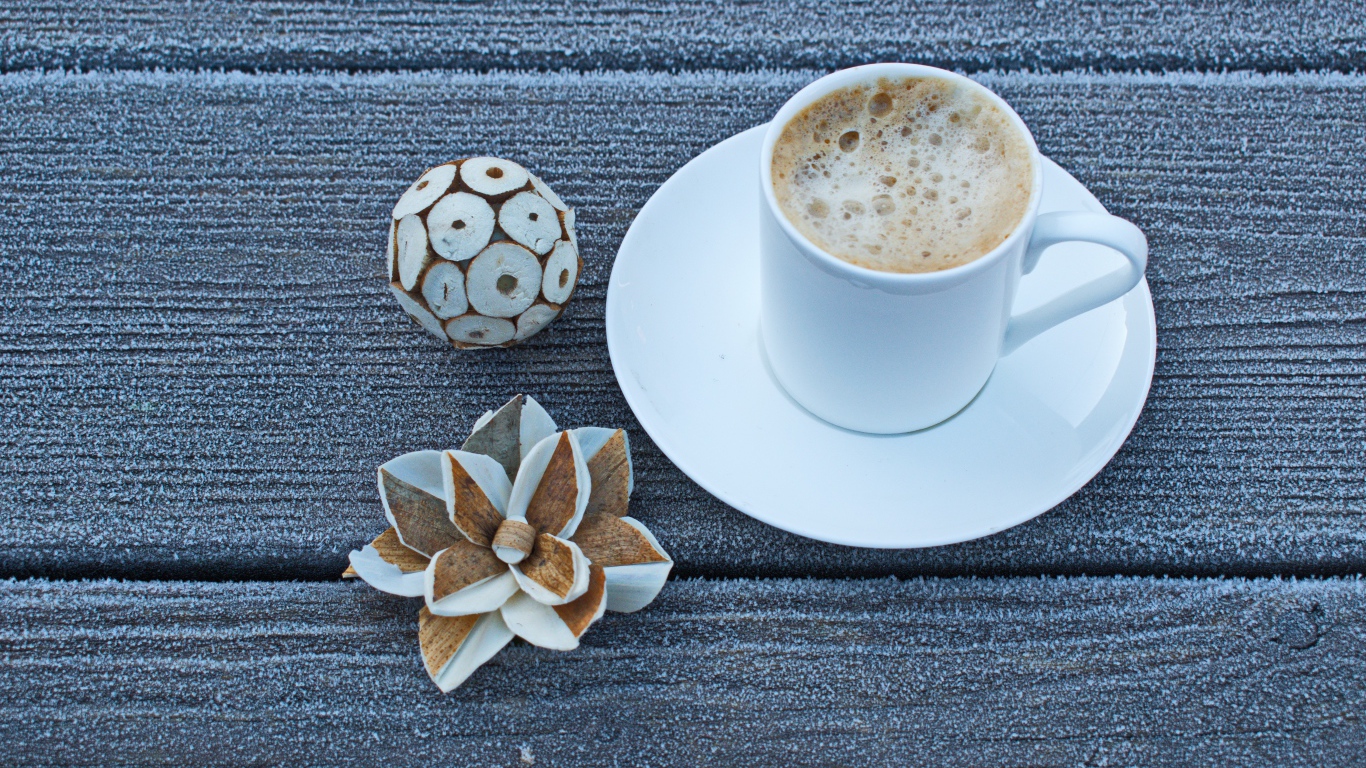 Чашка горячего кофе на покрытом инеем столе 