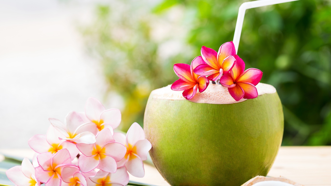 Коктейль в кокосе с цветами плюмерии 