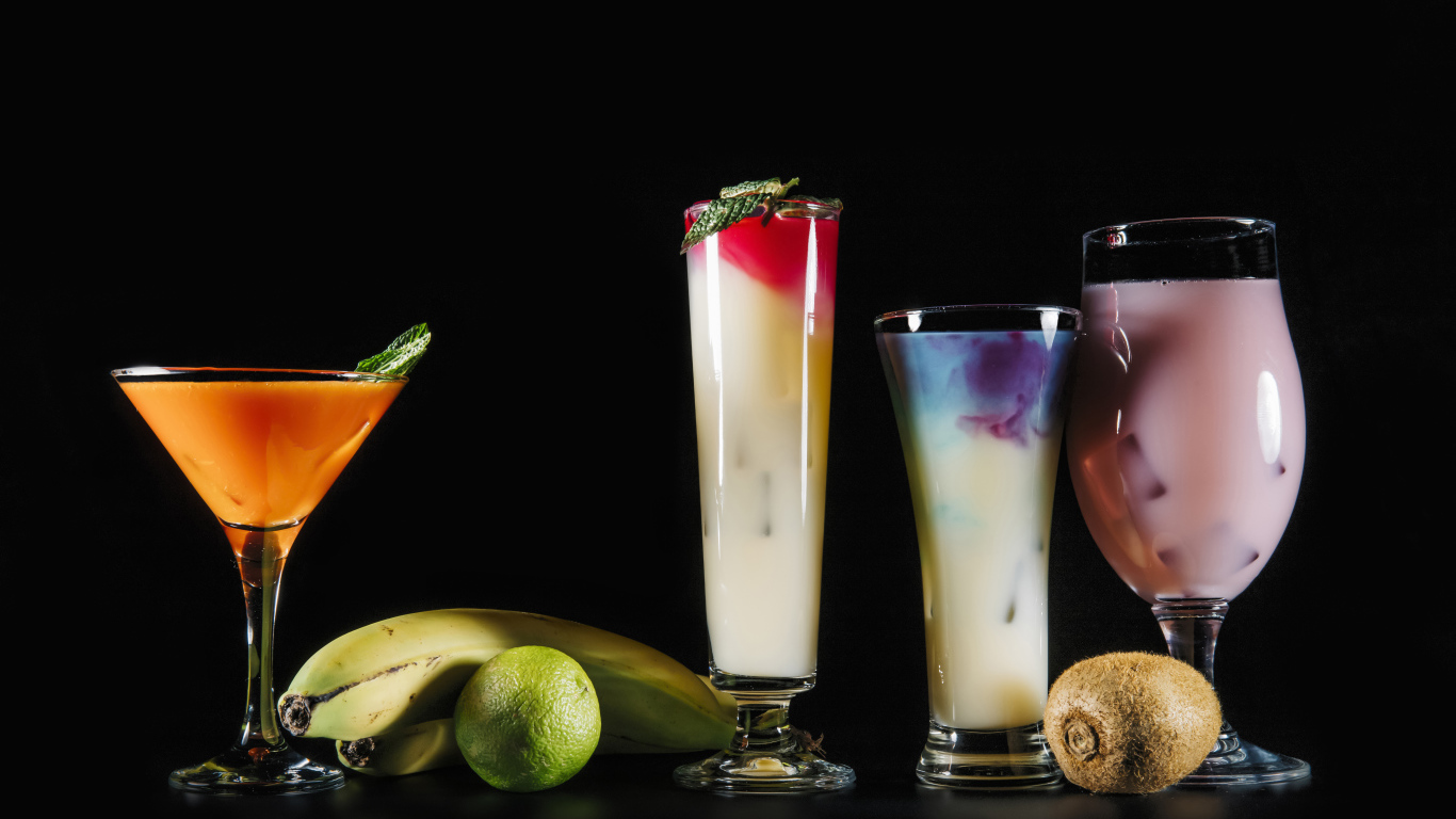 Вкусные тропические коктейли на черном фоне с фруктами