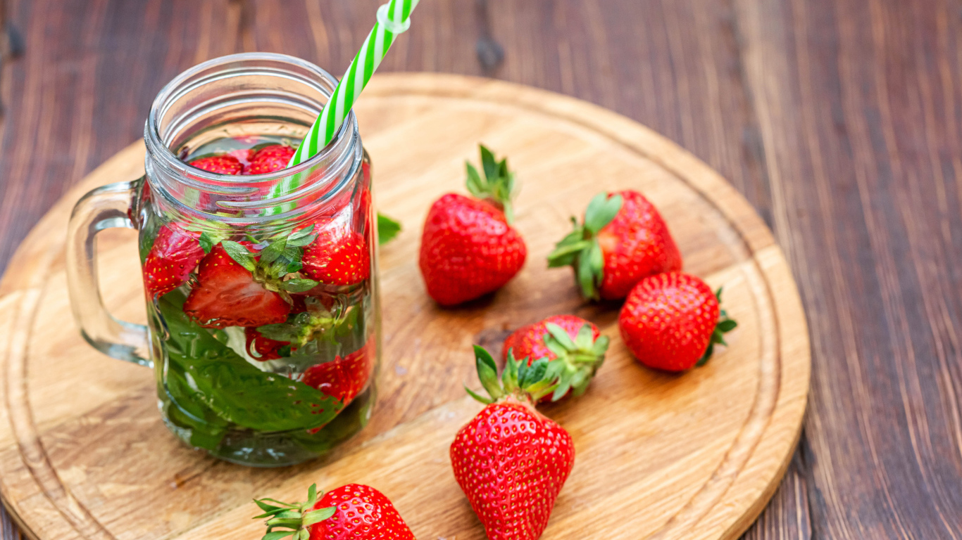 Напиток  в банке с ягодами клубники и трубочкой