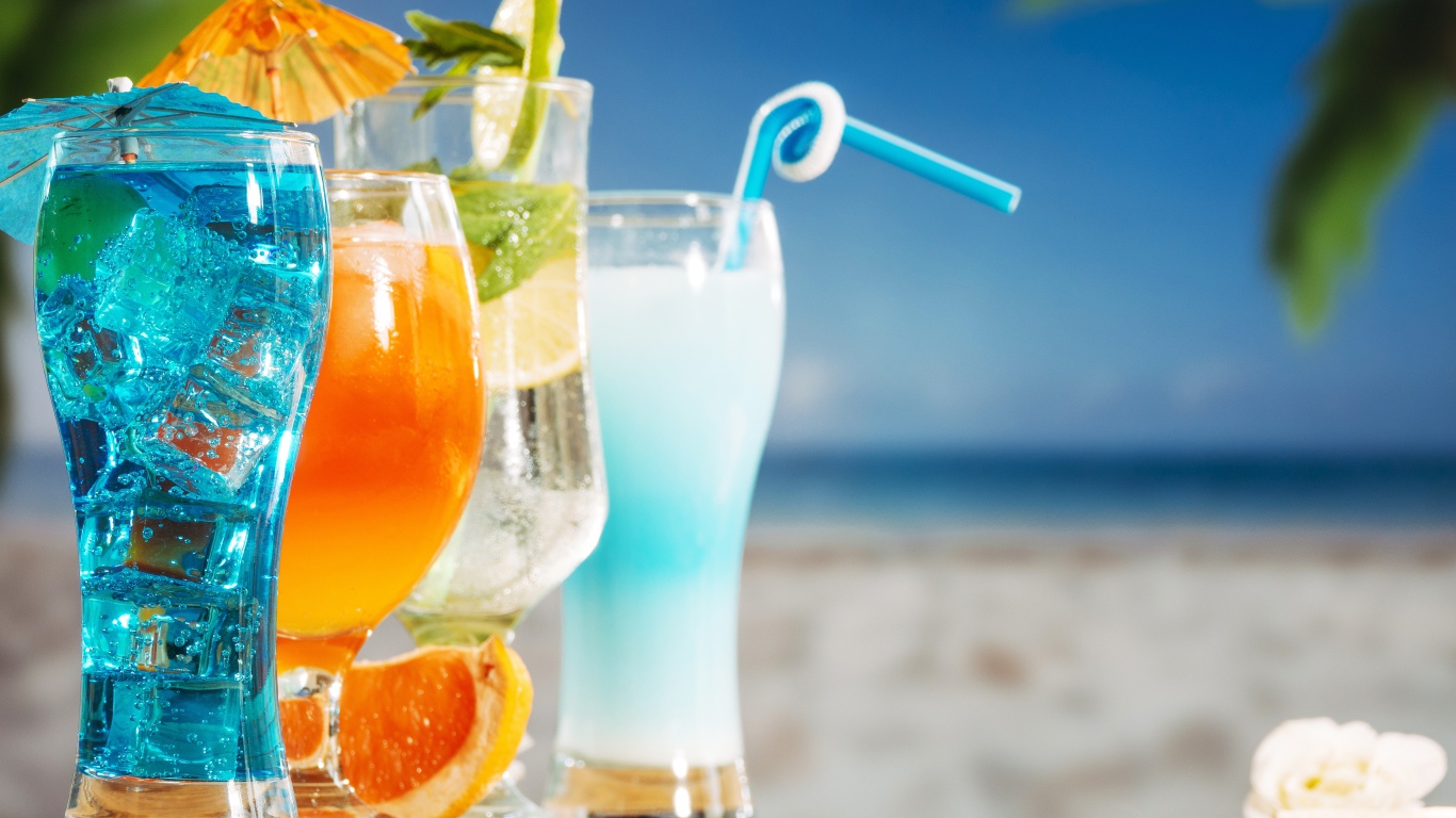 Четыре коктейля стоят на столе пляже 