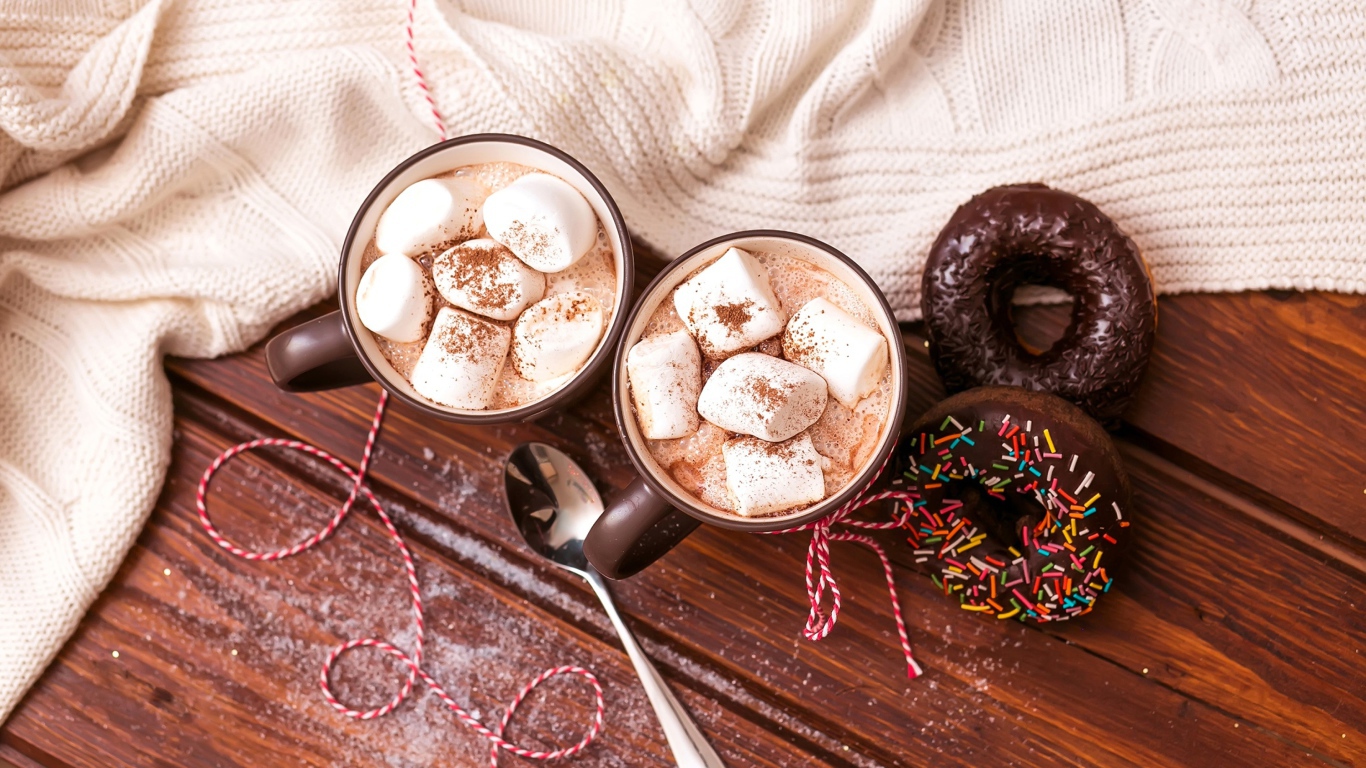 Горячий какао с маршмеллоу с пончиками на столе 
