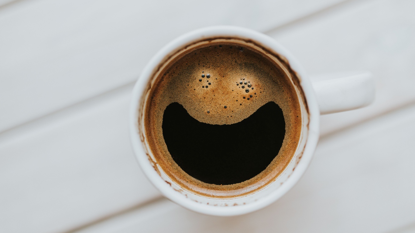 Улыбка на кофейной пенке в белой чашке