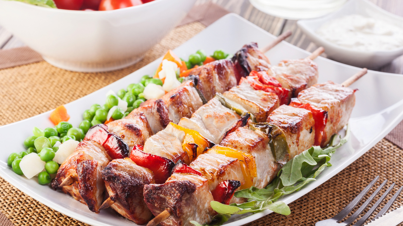 Аппетитный шашлык на тарелке с горохом