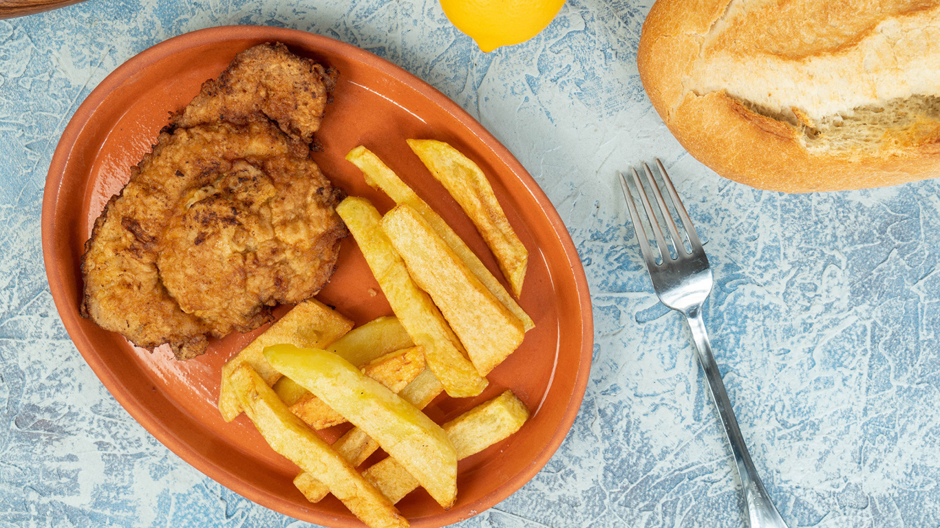 Отбивная с картофелем фри на тарелке 