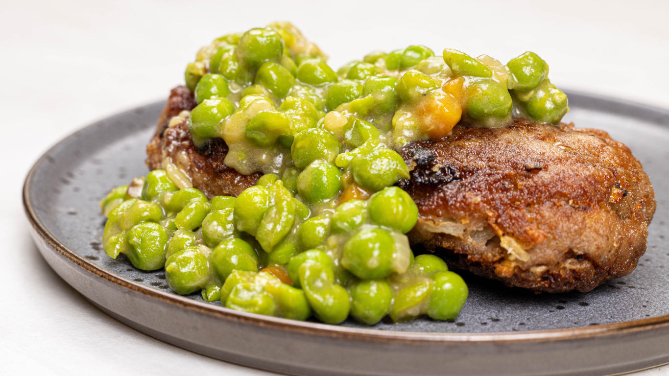 Котлета на тарелке с зеленым горошком