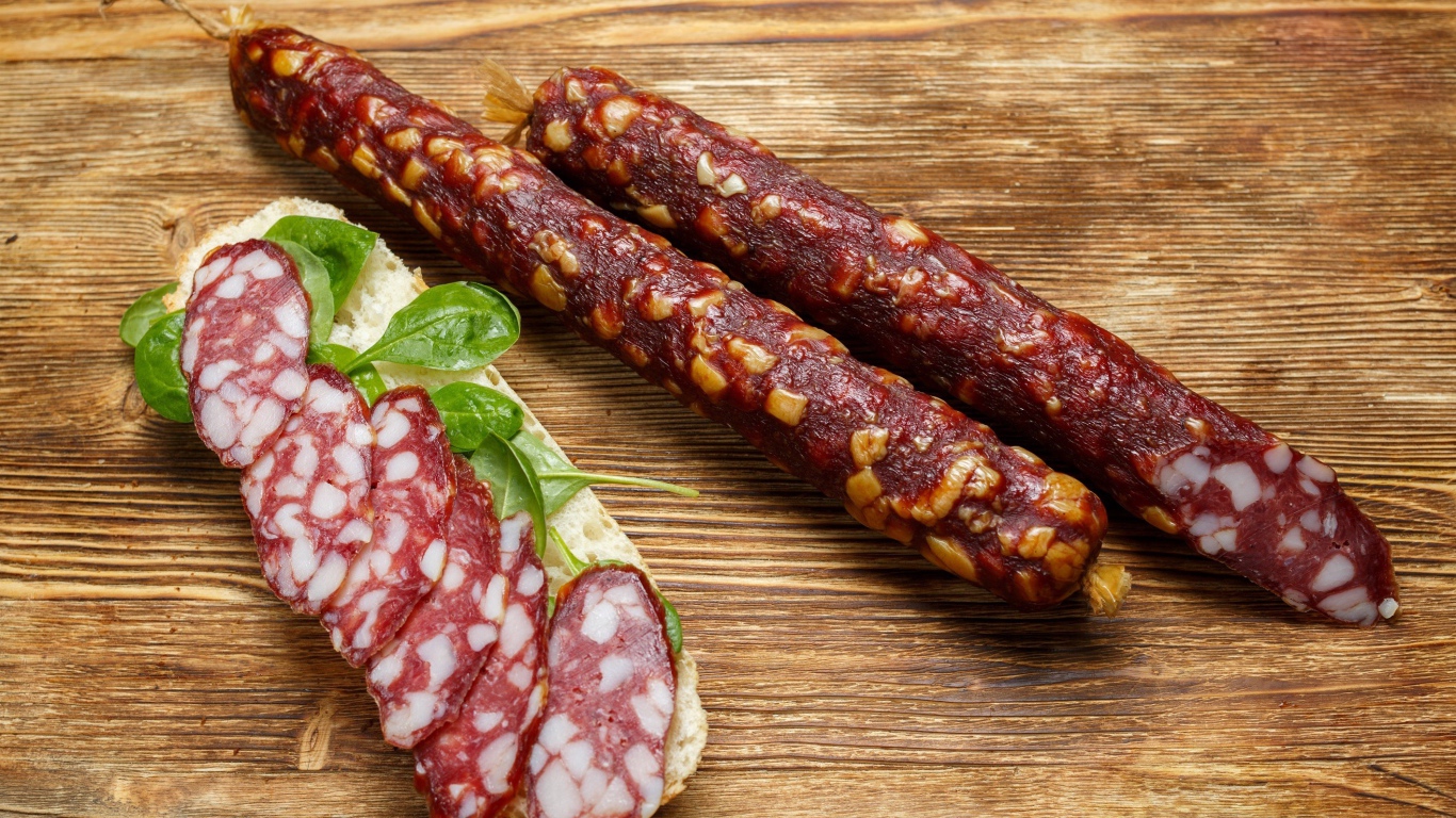 Вкусная сухая колбаса на столе с бутербродом