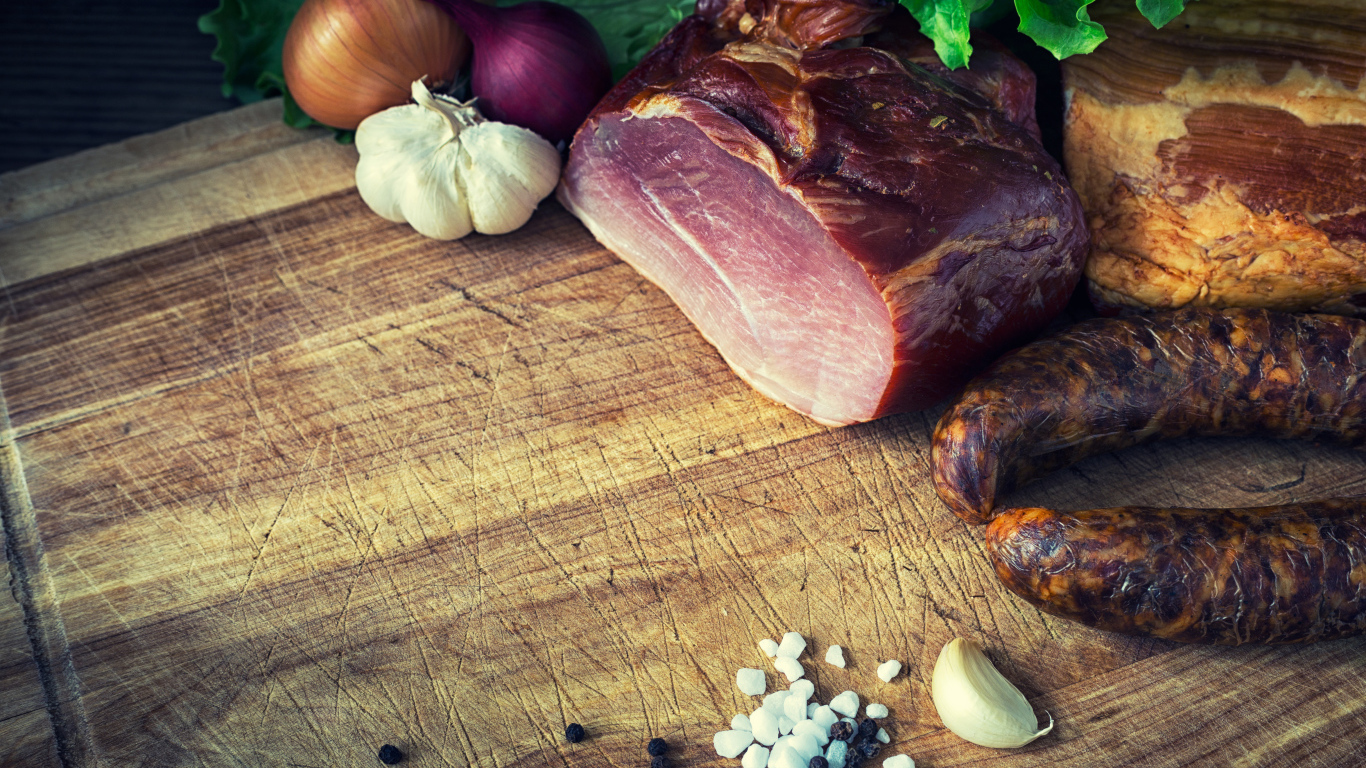 Мясные продукты на столе со специями, луком и чесноком 