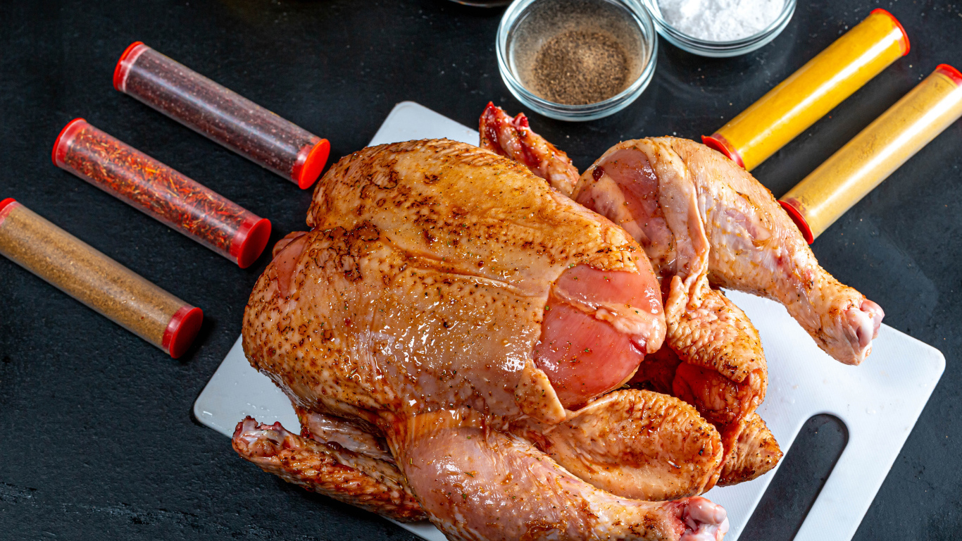 Сырая курица со специями на столе 