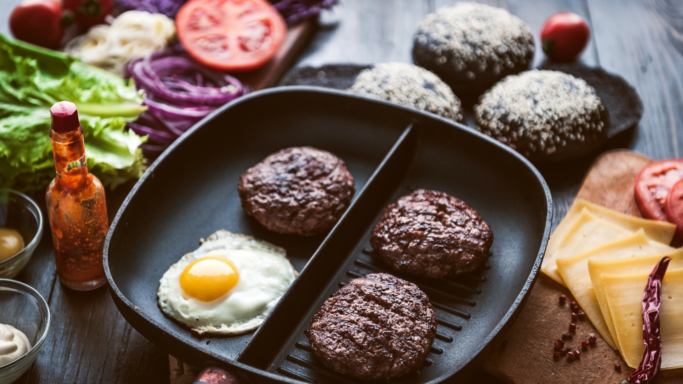 Три котлеты на сковородке с яичницей