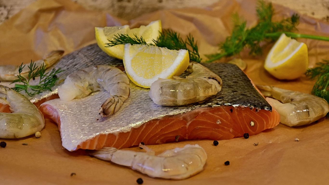 Кусок красной рыбы с креветками и лимонами