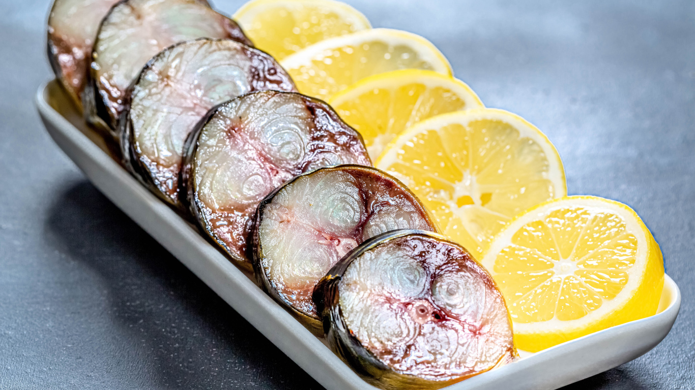 Sliced mackerel in a plate with slices of lemon