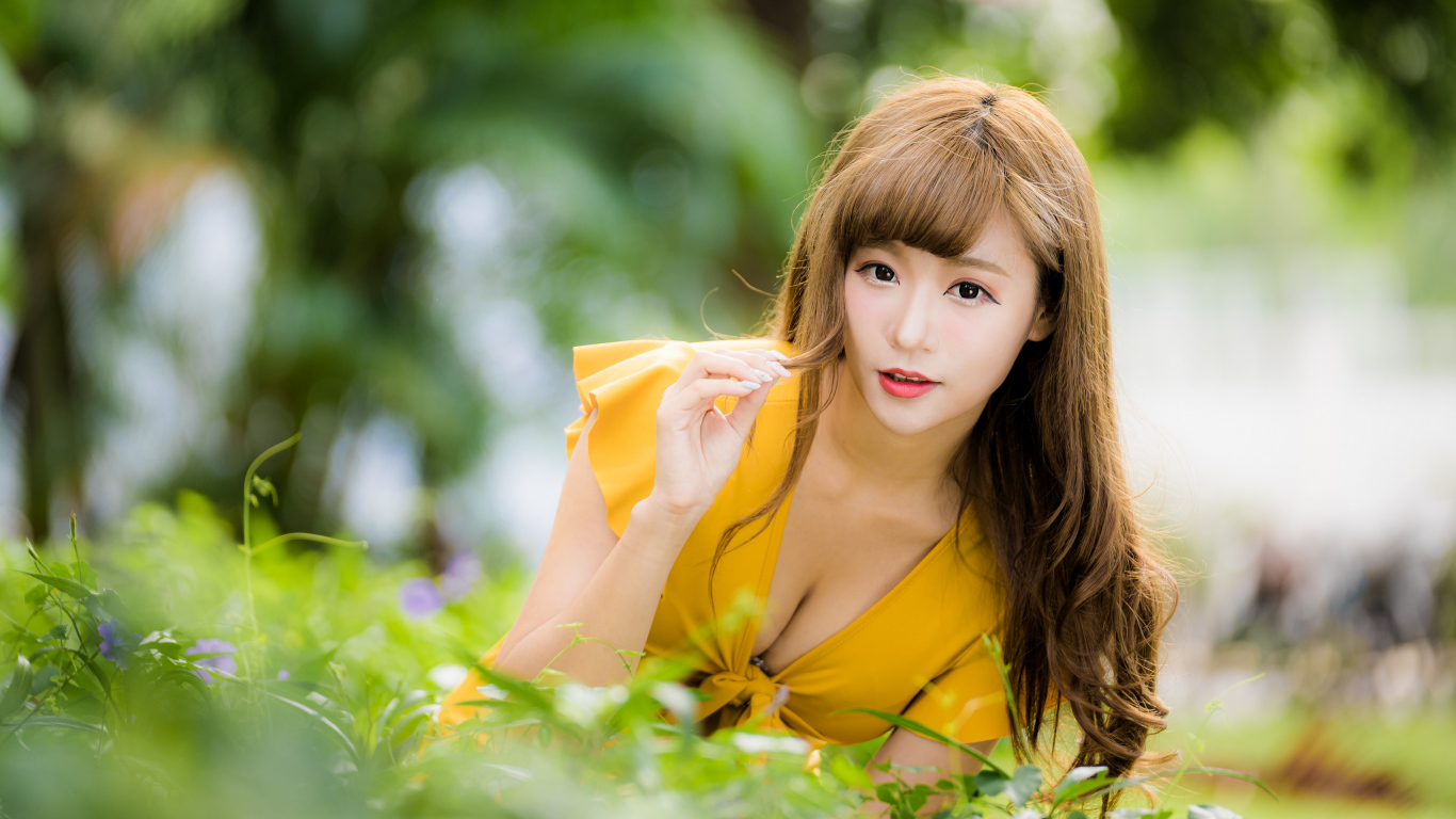 Девушка азиатка в желтом платье в парке 