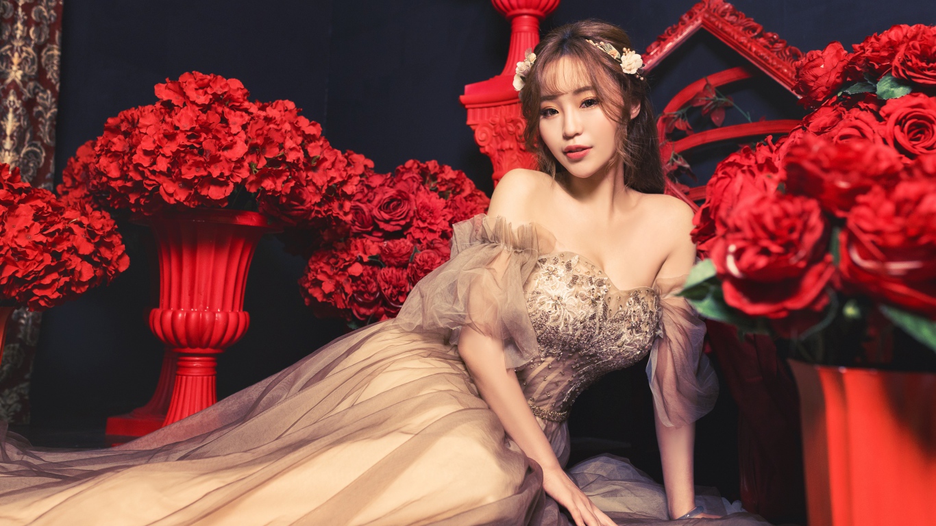 Азиатка в красивом платье в комнате с красными цветами