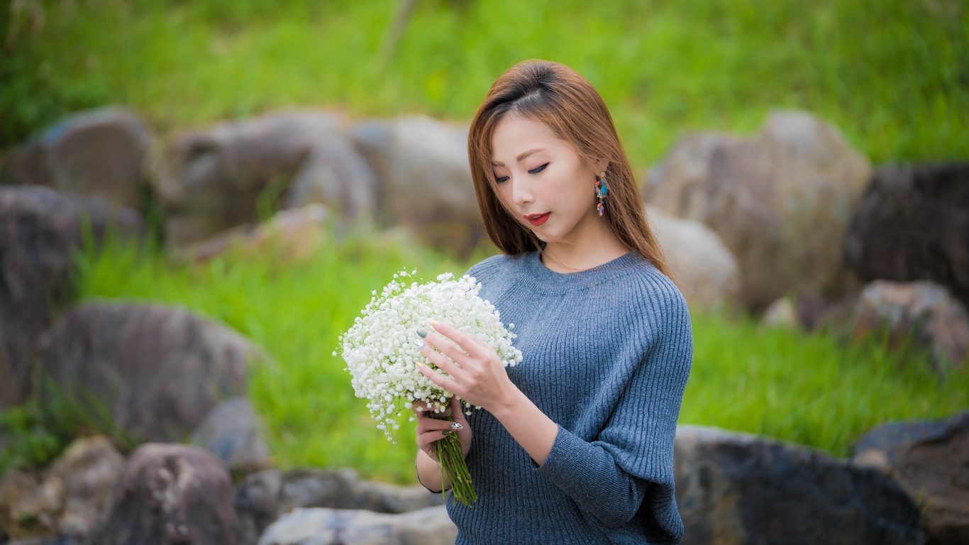 Красивая девушка азиатка держит в руках букет белых цветов