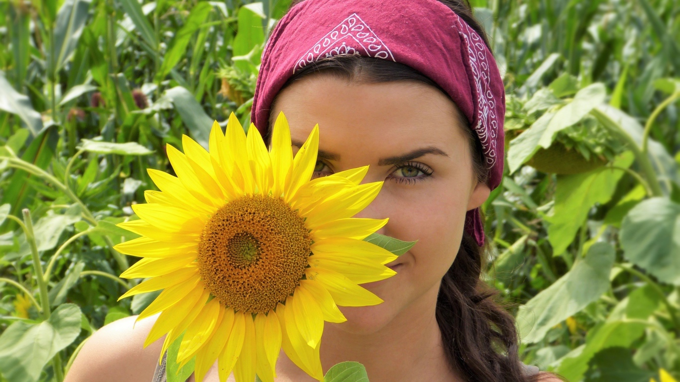 Красивая девушка держит в руках цветок подсолнуха