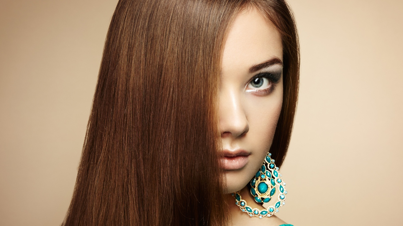 Красивая девушка в голубом платье с сережками в ушах