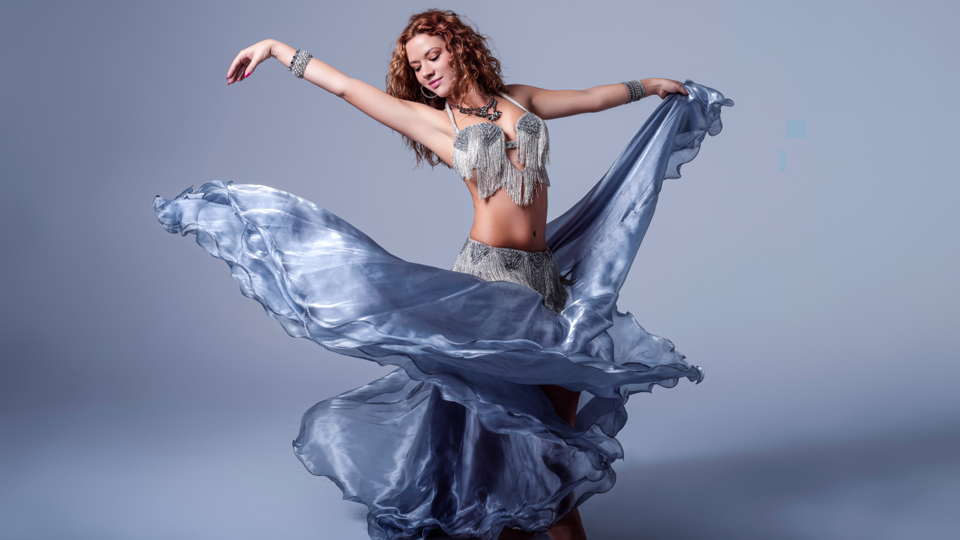 Красивая девушка в платье для танцев на сером фоне