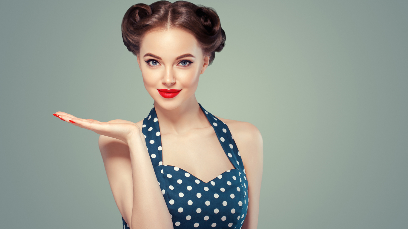 Красивая девушка в платье в горошек на сером фоне