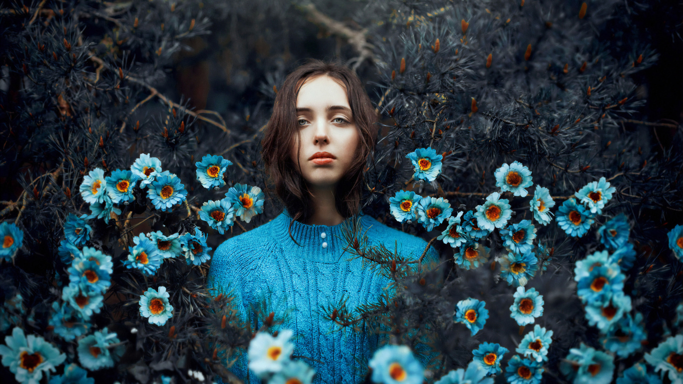 Красивая девушка колючих зарослях с голубыми цветами