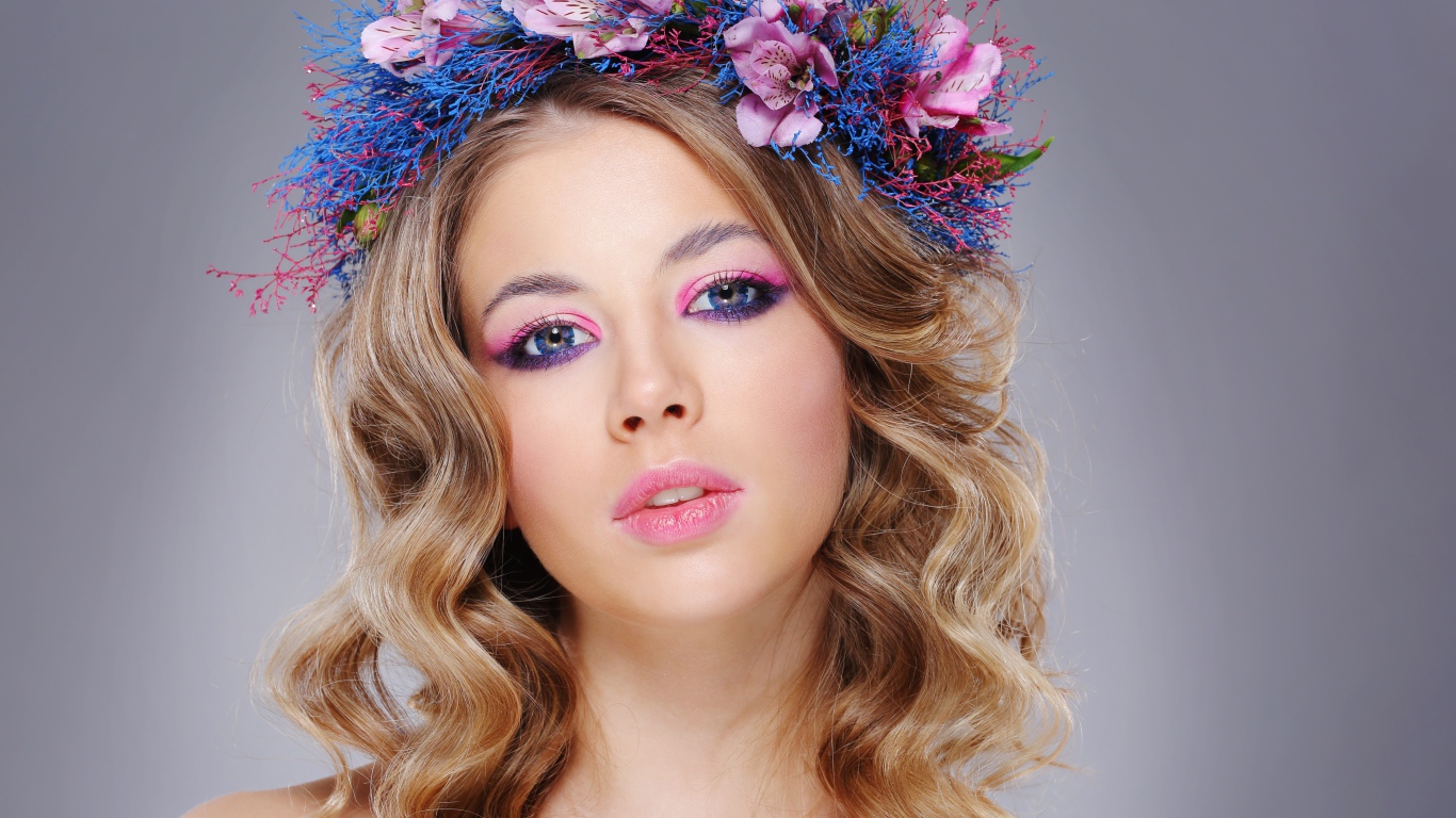 Красивая девушка с нежным макияжем с венком на голове на сером фоне