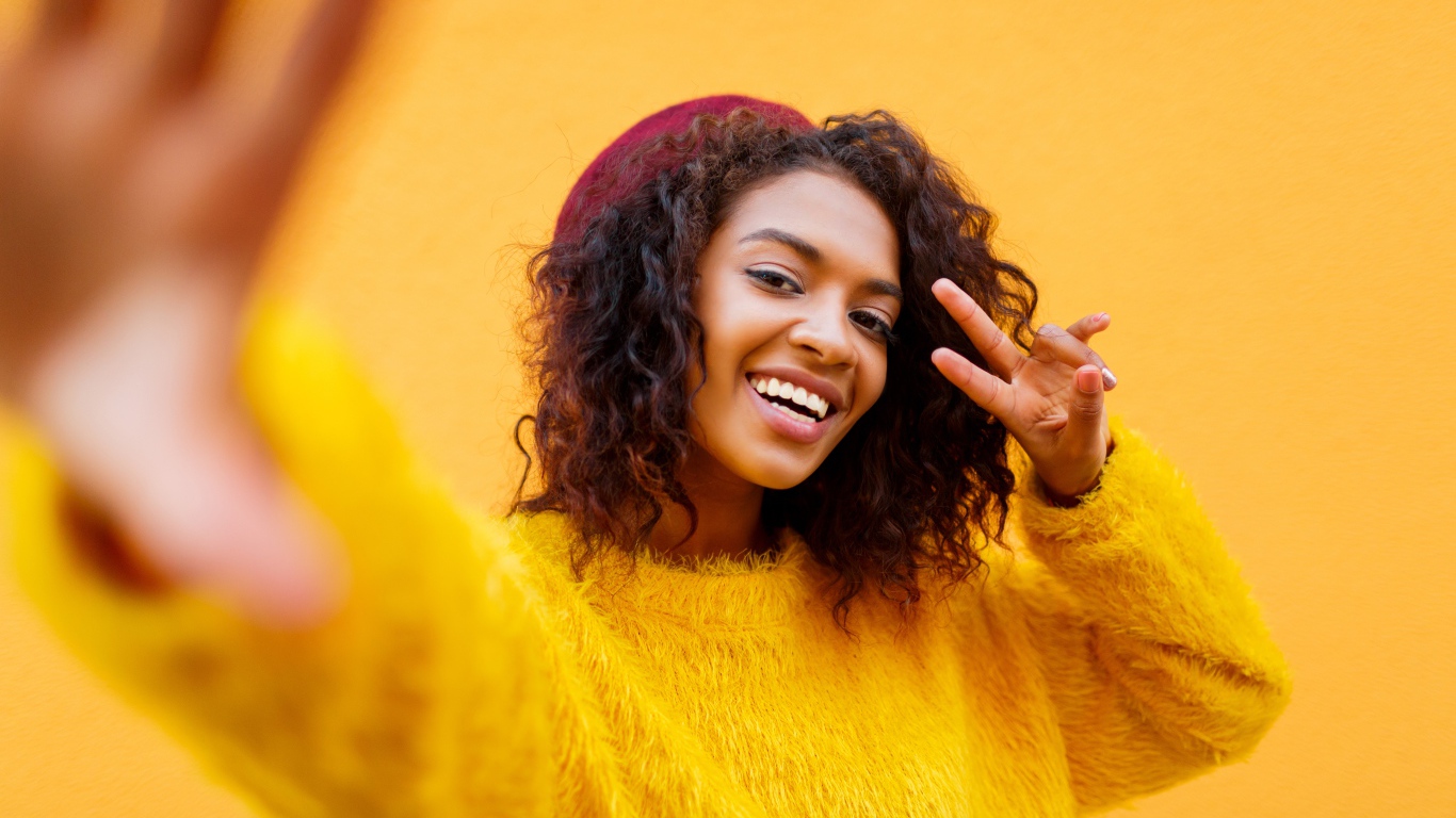 Красивая девушка мулатка в желтом свитере 