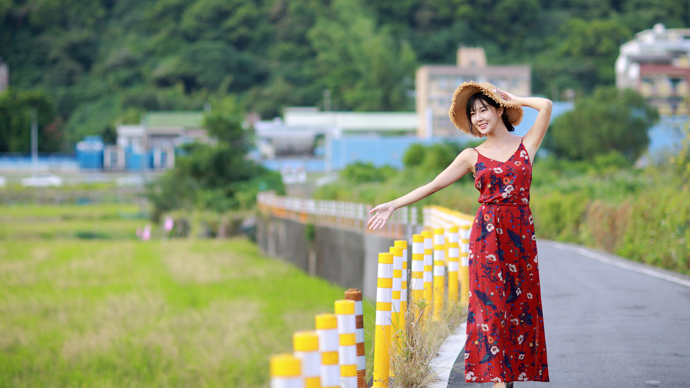 Веселая девушка азиатка в цветастом сарафане 