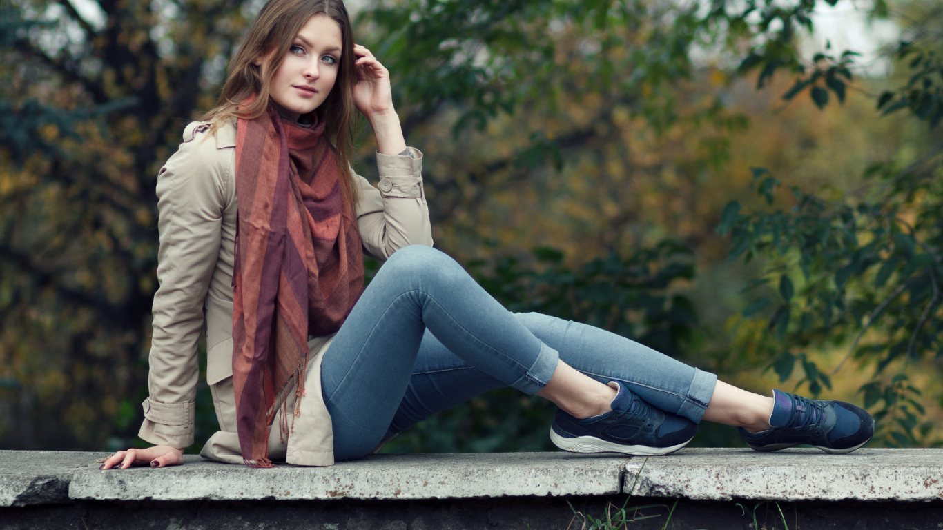 Милая девушка в куртке и синих джинсах 