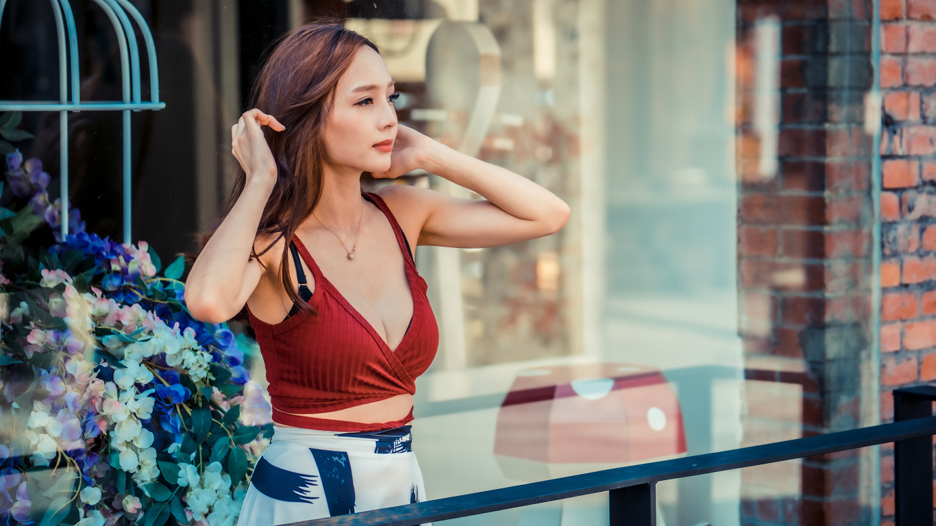 Нежная девушка азиатка стоит на балконе 